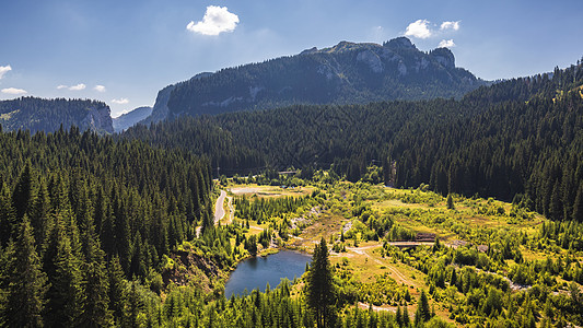 观测到Bolbosoci湖与喀尔巴阡山脉的堤坝环境森林池塘风景荒野植被蓝色树木旅行远足图片