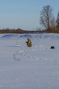 冬季天用冰上的角头和钓竿图片
