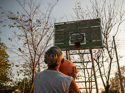 夏季日 亚洲老年男子在操场打篮球 健康生活方式和保健概念是健康的 笑声男性退休民众运动装男人阳光游戏公园玩家活动图片