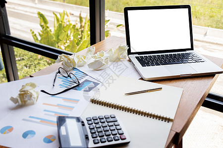 带有空白空白屏幕和纸张的笔记本电脑作为图表和图形帐户在工作场所使用计算器 商业财务 投资 审计和分析图片