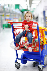 坐在购物车的适龄儿童购物市场商业顾客产品家庭零售部门大车食物图片