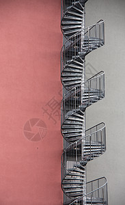螺旋楼梯作为紧急出口 在休斯的外侧金属建筑火灾逃生红色阶梯职业石工图片