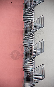 螺旋楼梯作为紧急出口 在休斯的外侧建筑火灾红色逃生职业石工金属阶梯图片