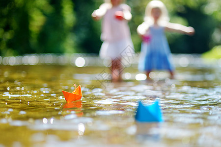 两个小妹妹玩纸船的两姐妹孩子季节森林享受团队折纸姐姐女孩溪流公园图片