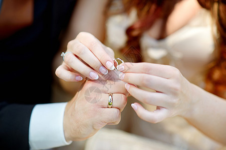 新娘和新郎握着结婚戒指图片