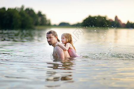 小女孩和她父亲在河里玩得开心图片