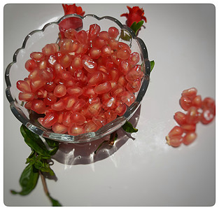 碗里的石榴籽 里面有闪亮的红色宝石 花蕾放在碗里 漂亮地放在白盘里石榴石甜点农业健康水果热带饮食食物团体浆果背景