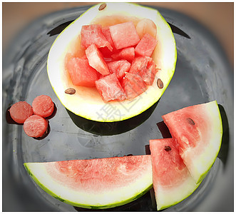 新鲜彩色西瓜切块 碗形西瓜外壳 切片和圆形块 放在黑色盘子里 适合夏天吃 健康水果 也能保持身体水分图片