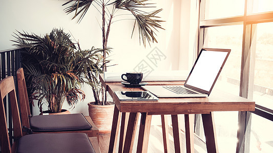 办公室工作场所 笔记本电脑放在木桌上 靠窗文档技术房间工作药片阳光自由职业者咖啡桌子窗户图片