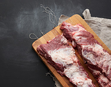 肋骨上的猪肉肉 木制切割板上有一层脂肪图片