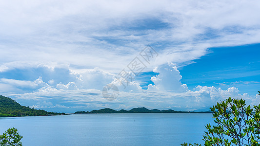 热带岛屿背景 蓝色天空中云雾飘散图片