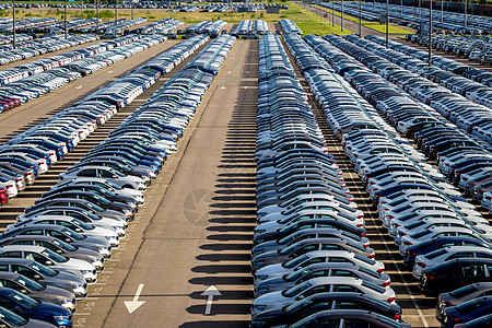 在阳光明媚的日子里 一排排新车停在一家汽车厂的配送中心 露天停车车辆引擎工厂销售人群发动机经济学汽车工业出口经销商图片