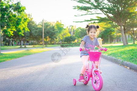 小女孩骑自行车孩子 可爱的亚洲小女孩 骑自行车在公园里运动娱乐骑术女性孩子们阳光闲暇童年女孩乐趣背景