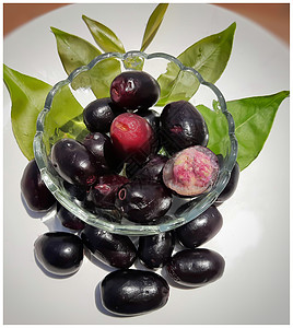 碗中的黑梅子 用叶子装饰的美极了 含有维生素C和铁血红蛋白心脏健康 并治疗糖尿病夏季水果食物饮食紫色甜点植物李子草药团体药物图片