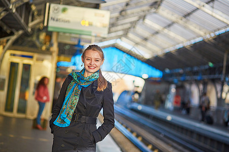 等待巴黎地下地铁平台火车的年轻女子 为她们服务女孩工作城市铁轨车站旅行白色女士交通民众图片