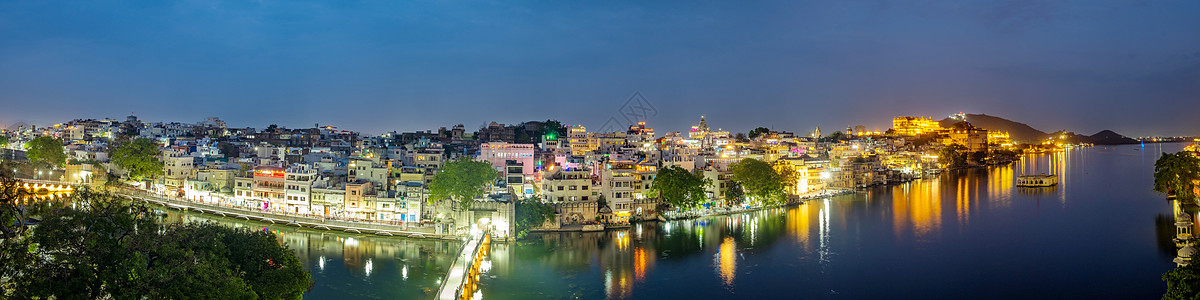 乌代普尔市位于印度拉贾斯坦邦Pichola湖景观日落反射锯齿建筑天空旅行蓝色吸引力历史图片