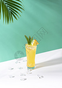 杯子里的冰菠萝鸡尾酒 在绿色背景上 夏季饮料图片