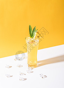 杯子里的冰菠萝鸡尾酒 在黄色背景上 夏季饮料图片