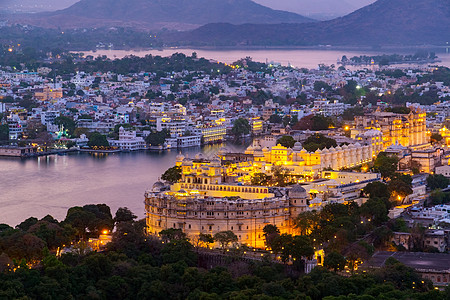 乌代普尔市位于印度拉贾斯坦邦Pichola湖旅游日落锯齿建筑神殿建筑学全景反射景观吸引力图片