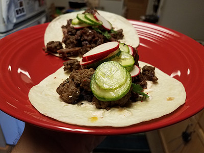 牛肉萝卜厨房的红盘子上加黄瓜和萝卜小吃午餐食物红色盘子背景