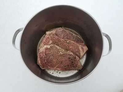 牛肉牛排 配有调料和雪上金属锅中的液体冷冻午餐白色食物牛扒图片