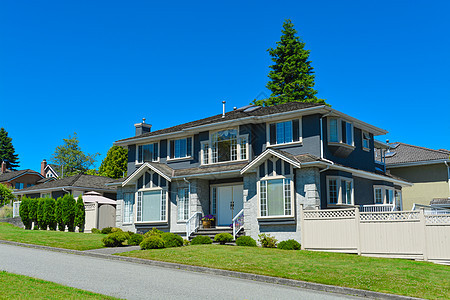 温哥华郊区的大家族住宅 在蓝天背景下沥青家庭入口园林灌木丛窗户建筑学门廊蓝色财产背景图片
