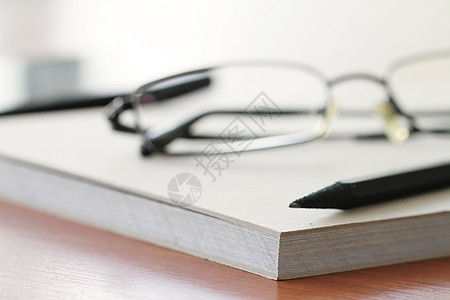 在办公室木制桌子上用铅笔贴着纸条木头软垫笔记纸休息床单商业笔记本白色会议空白图片