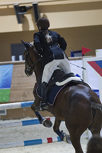 骑着黑马的年轻骑手 在表演跳跃比赛中奔跑运动马术女孩皮革带子荒野鬃毛乡村舞步座位图片