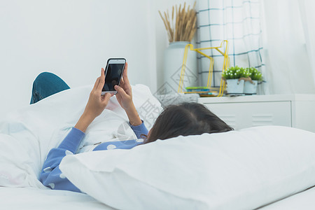 妇女醒来后在床上使用电话背景图片