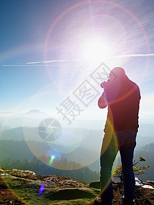 高个子正在用镜像摄影机拍摄脖子的相片 雪地岩石山峰峡谷枝条橙子阳光公园湿度树干射线单反反转图片