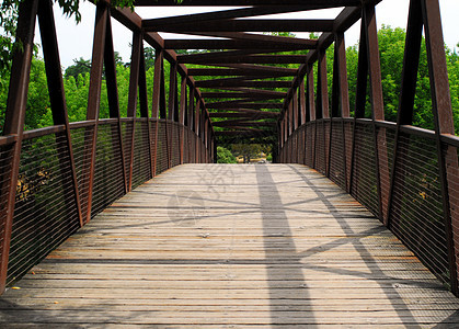 公园中的桥梁小路穿越跨度大梁灰色金属树木行人阴影基础设施图片
