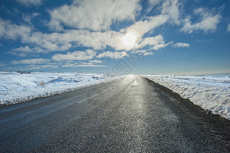 穿过冬季农村地区乡村地带的乡村公路天空沥青草地白线旅行消失蓝色阳光太阳英语图片