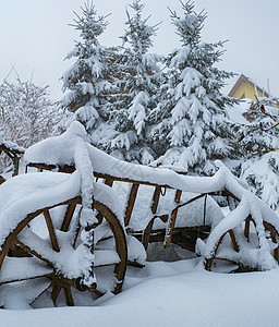 雪雪覆盖的旧木车图片