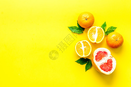餐桌上有树叶的橙子和葡萄果 顶端视图复制空间柠檬热带粉色柚子叶子水果红色绿色文本黄色图片
