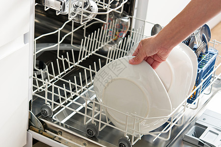 女人从洗碗机里拿盘子高清图片