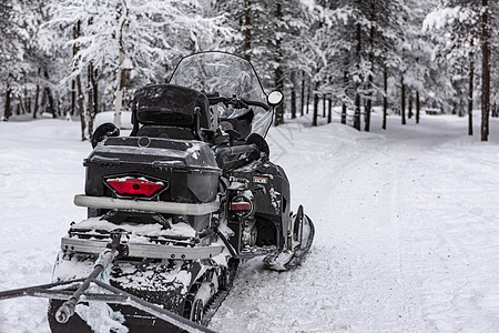 在雪覆盖森林的足迹上 黑色冰霜涂在雪地上的雪车图片