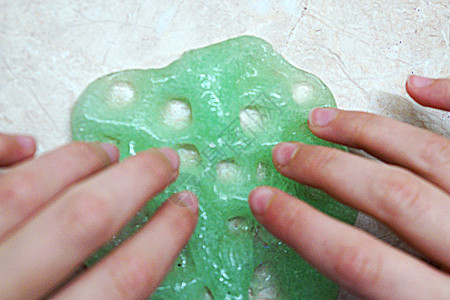 孩子的手玩 与绿色粘液紧贴按摩实验手指爱好玩具娱乐胶水橡皮细绳白色图片