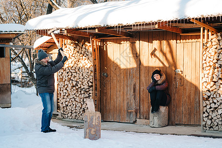 穿着冬衣的家伙 在院子里砍木头劈柴惊喜太阳日志木柴喜悦工作斧头雪堆夫妻图片