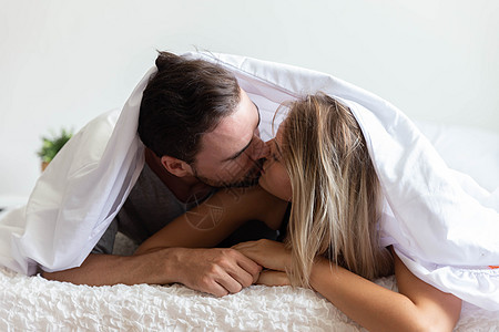 一对在床上的情侣 像一个快乐的爱人一样亲吻图片