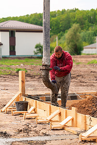 建筑工人用自动泵将水泥或混凝土铺入基础工程的水泥或混凝土基础设施就业备案固井活动项目碎石液体钢筋金属图片