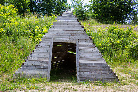 作为帐篷住宿的木金字塔小屋天空树木草地棕色入口住宅绿色金字塔木板图片