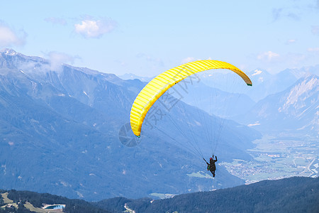 蓝天的滑翔伞在美丽的山上飞扬空气旅行航班男人乐趣冒险蓝色飞行员运动自由图片