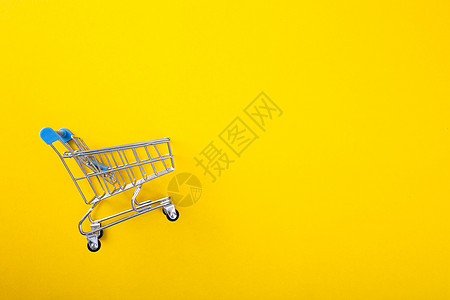 黄色背景的购物小车零售贸易顾客购物车公司市场产品运输销售商业背景