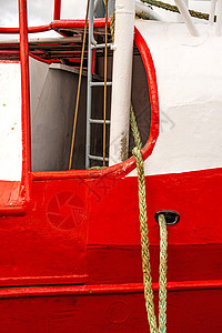 拖网渔船在红船体上栏杆船运港口红色晴天航海麻绳安全海洋图片
