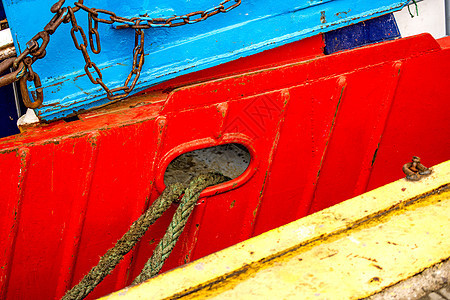 拖网渔船在红船体上海洋安全航海晴天麻绳黄色蓝色船运港口栏杆图片