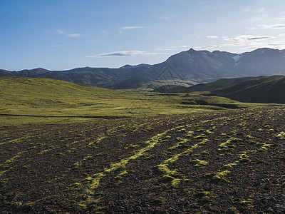 冰岛高地Fjellabak自然保护区的火山景观 雪覆盖山脉 绿色山丘和岩浆碎石土 岩石被大海花岗草覆盖碎石日落旅行小路蓝色自然远图片