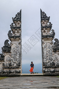 青少年站在印尼巴厘岛的Lampuyang寺庙门口旅行游客楼梯天空石头雕塑旅游男人纪念碑上帝图片