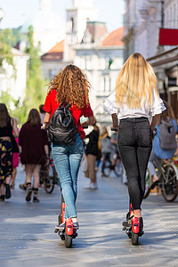 在城市环境中乘坐公共租赁电动滑板车的时尚时尚少女的后视图 斯洛文尼亚卢布尔雅那新型环保现代公共城市交通女孩青少年运输工具女性自行图片