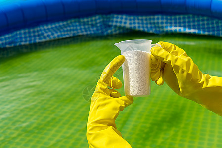 在池中添加氯粉 以去除藻类和消毒水 可充气游泳池护理概念水池质量考试治疗控制监控检查药片测量清洁度背景图片