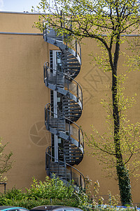 通往高楼大楼的钢螺旋钢楼梯 以备紧急情况生活天空宿舍火灾螺旋圆形金属树叶逃生出口图片
